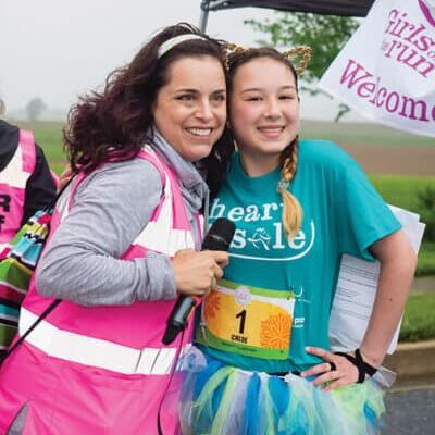 Jessamine Duvall, Executive Director of Girls on the Run Central Maryland, congratulates a young race participant.